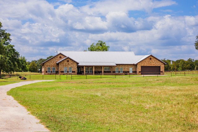 a front view of house with swimming pool and green space