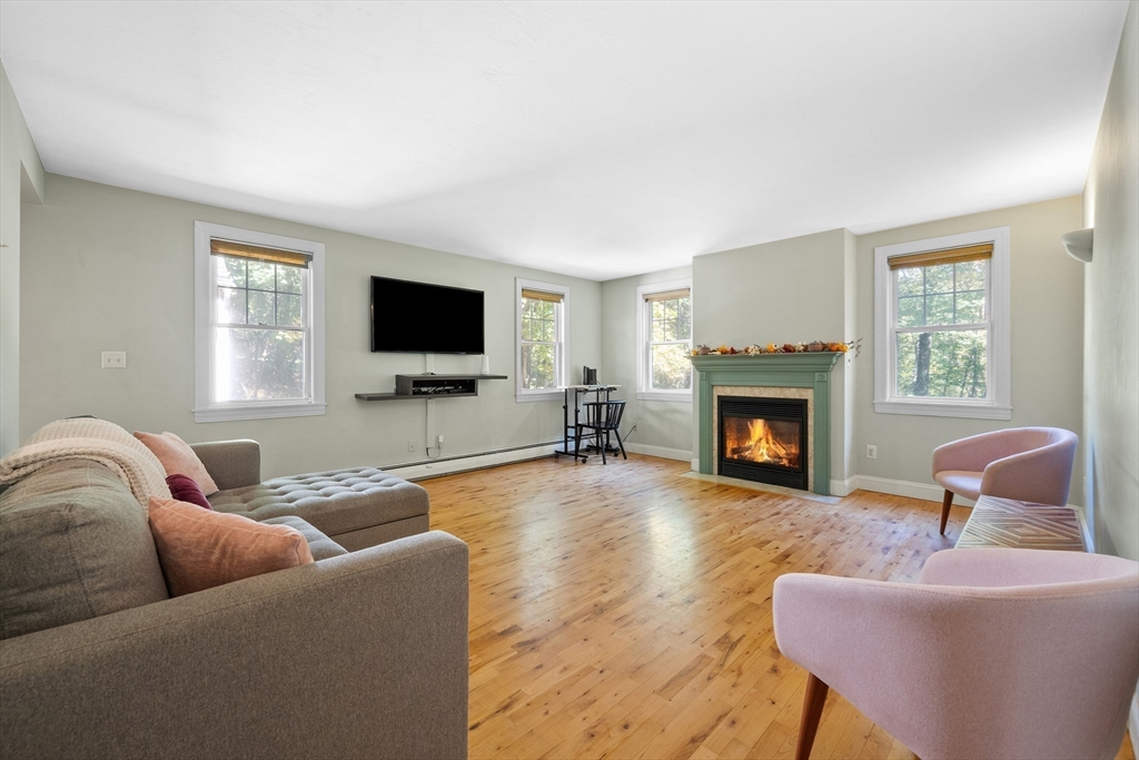 a living room with furniture a flat screen tv and a fireplace