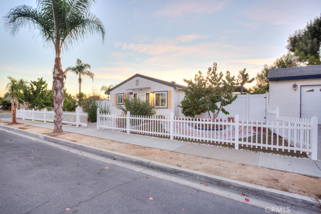 a view of a house with a small yard and palm trees