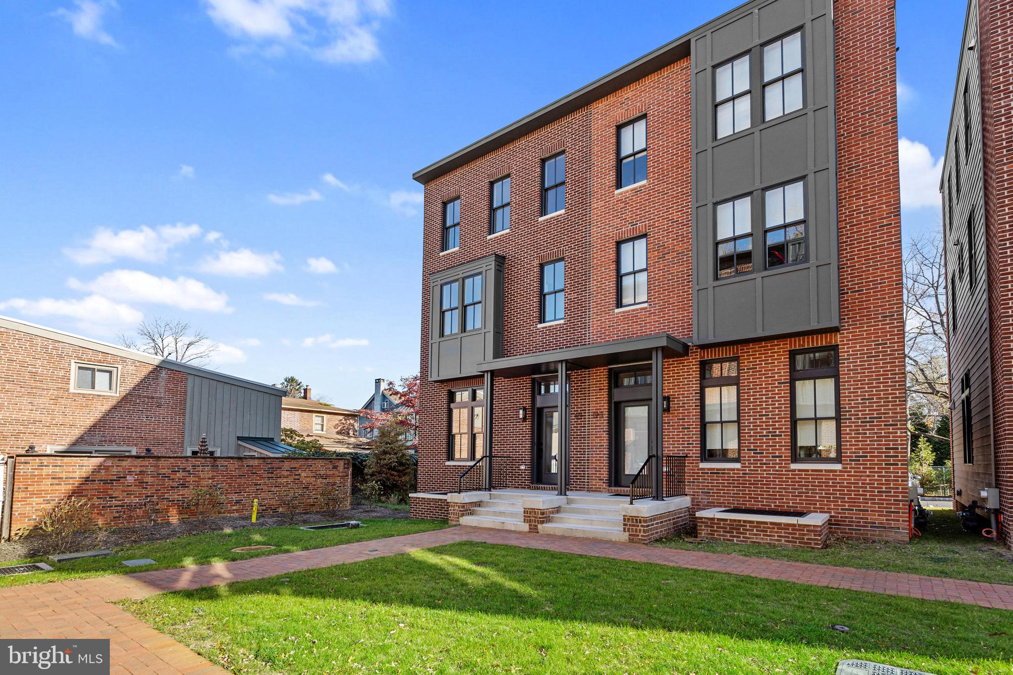 a front view of building with yard and outdoor seating