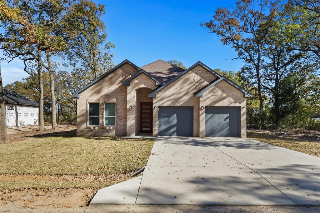 View of front of house with a garage and a front lawn