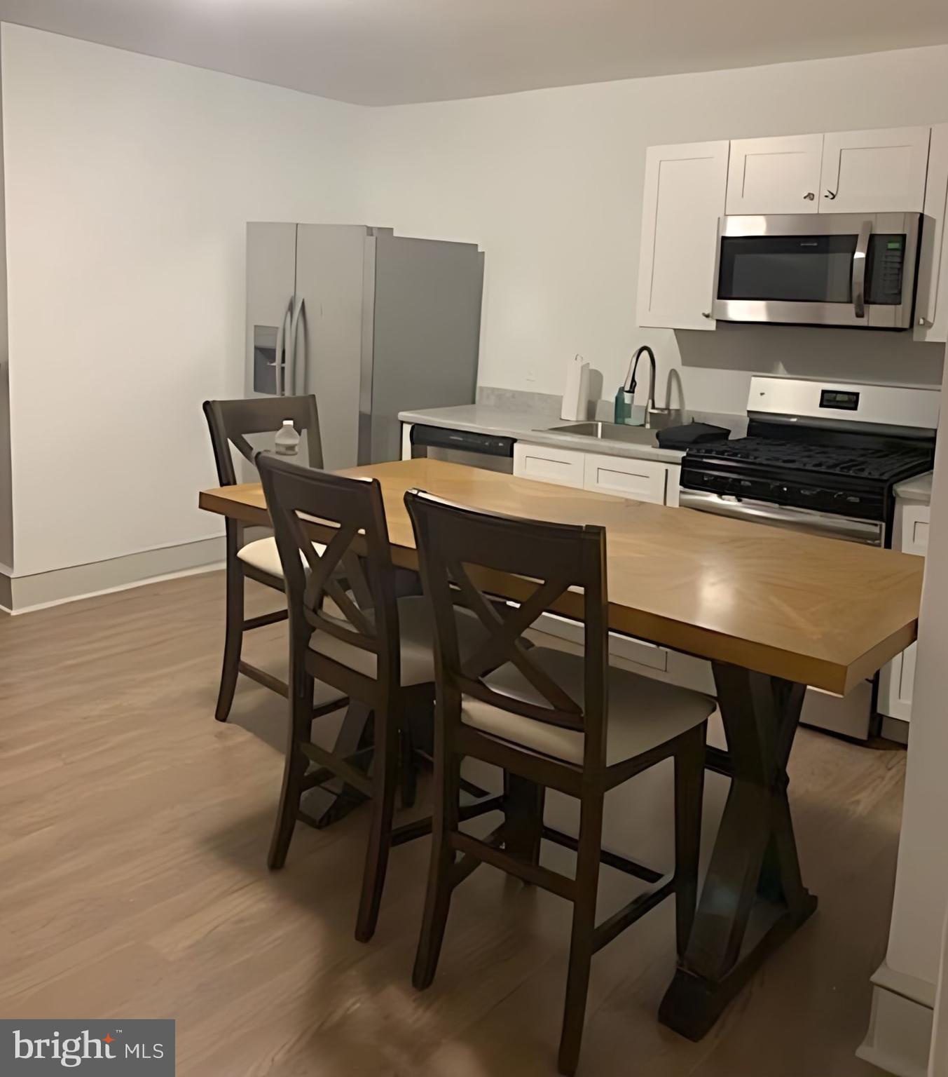 a kitchen with a table chairs microwave and cabinets