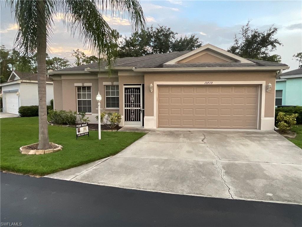 Ranch-style home with a garage and a lawn