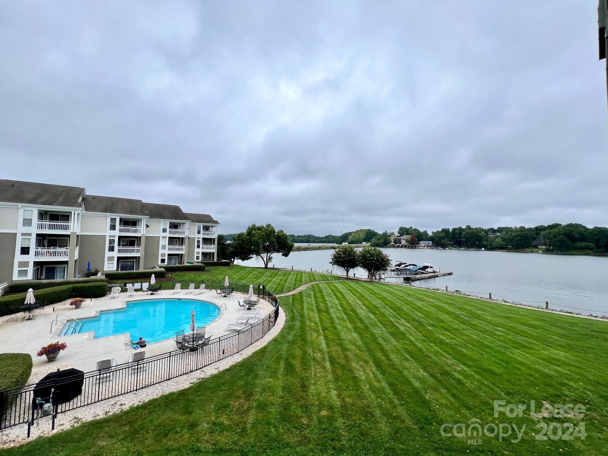 a view of a swimming pool with a patio and a yard