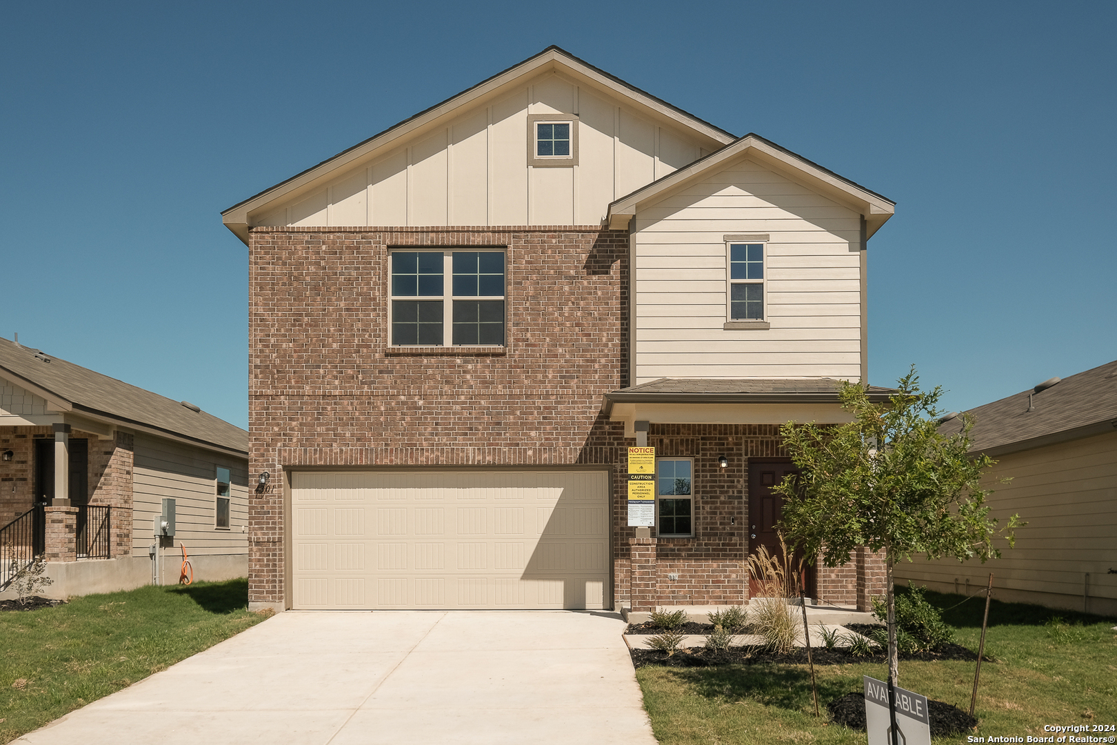 a front view of a house with a yard garage and outdoor seating