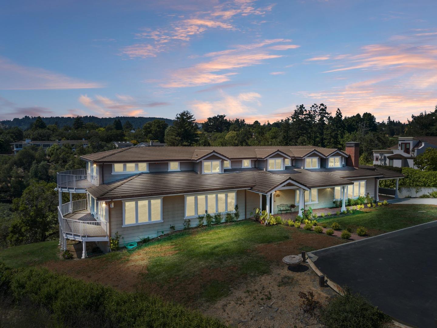 a view of a big house with a big yard and large tree