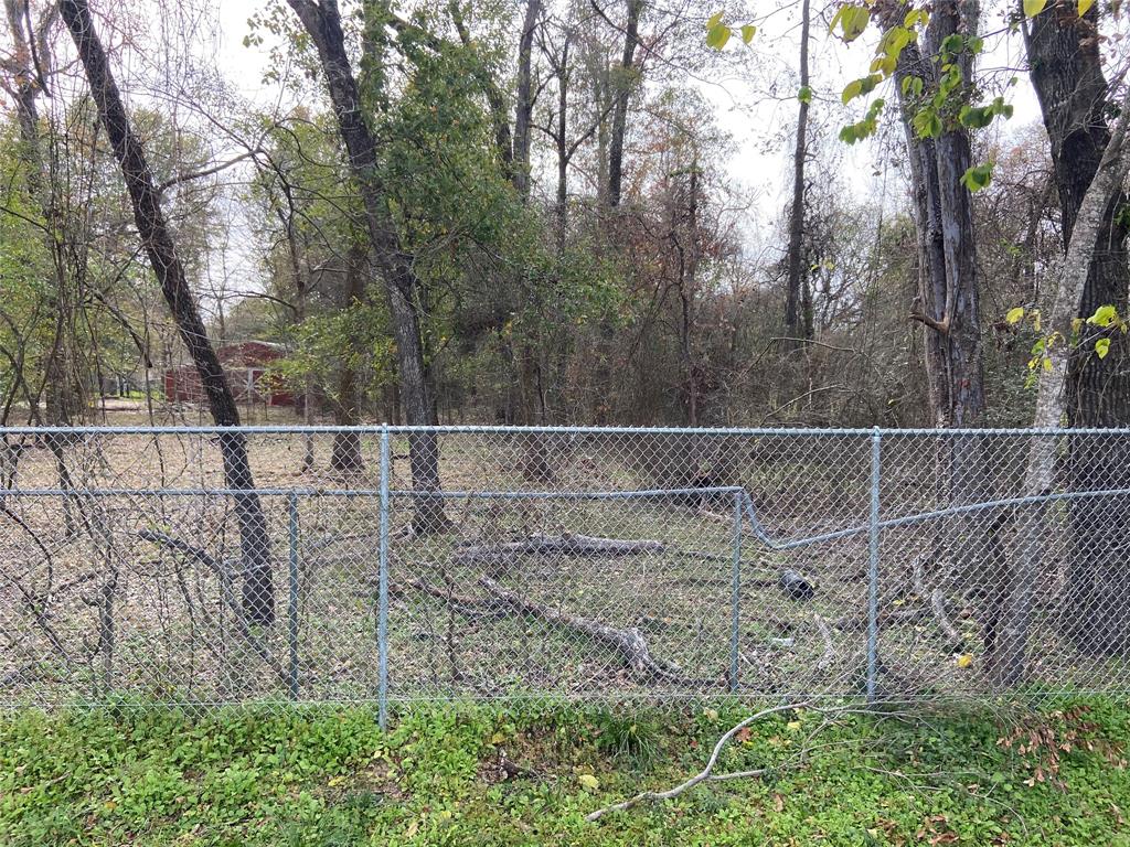 a view of a yard with wooden fence