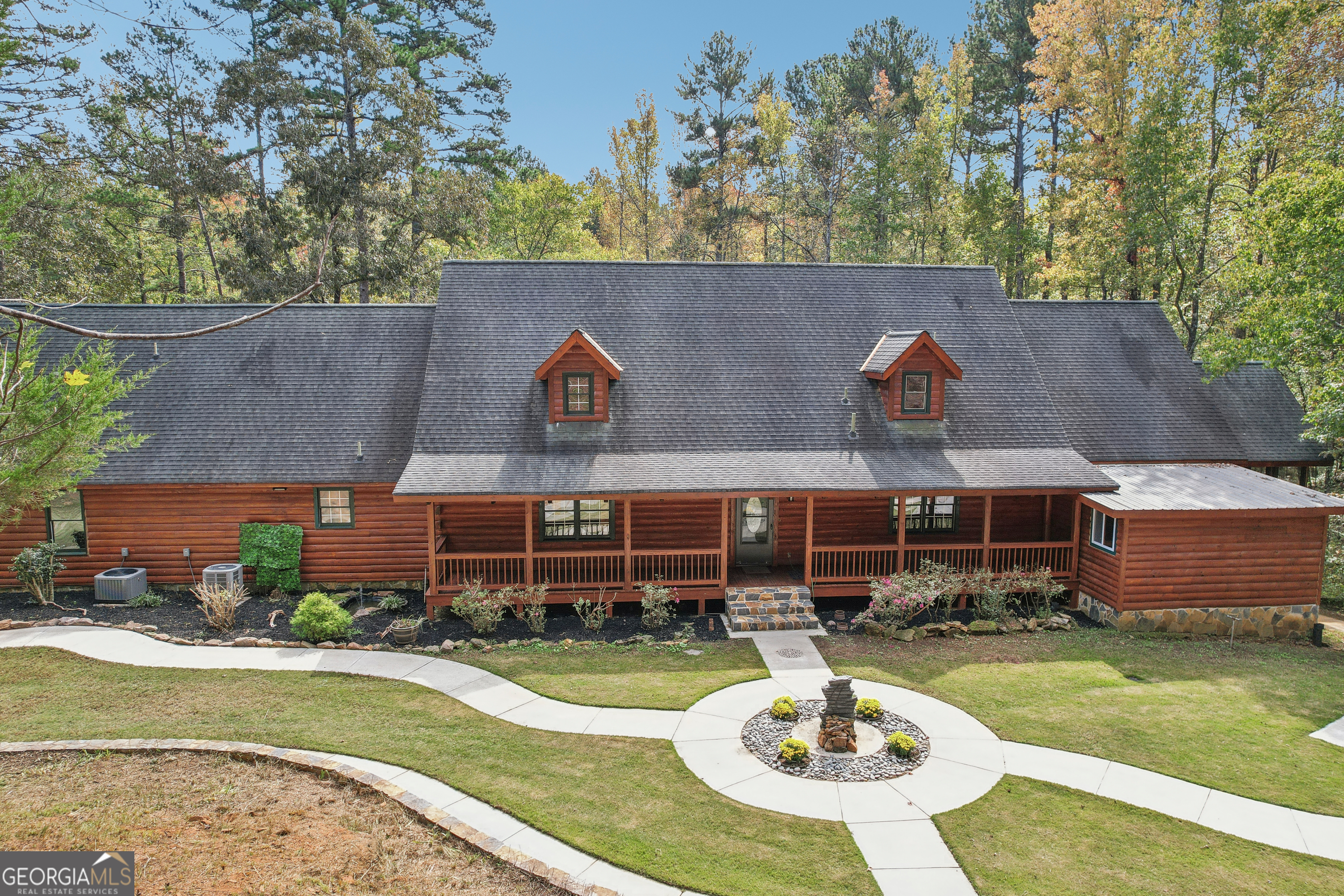 an aerial view of a house with swimming pool a yard and a patio