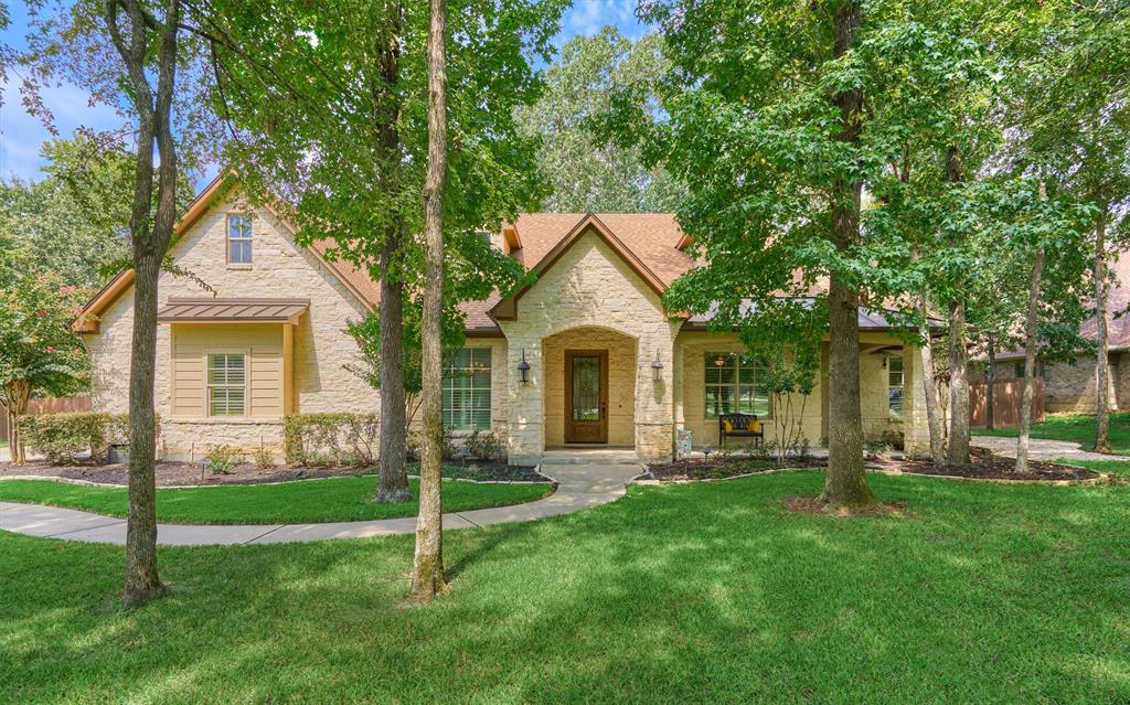 a front view of a house with a yard and trees