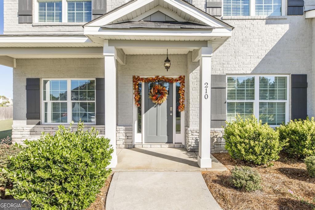 a front view of a house with a lots of flowers