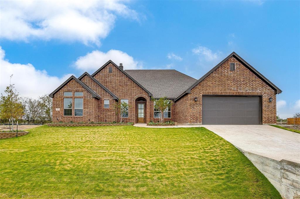 a front view of a house with yard and garage