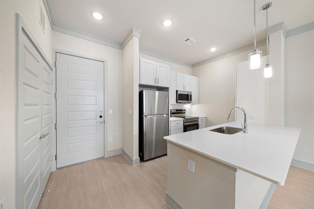 a kitchen with refrigerator cabinets and a sink