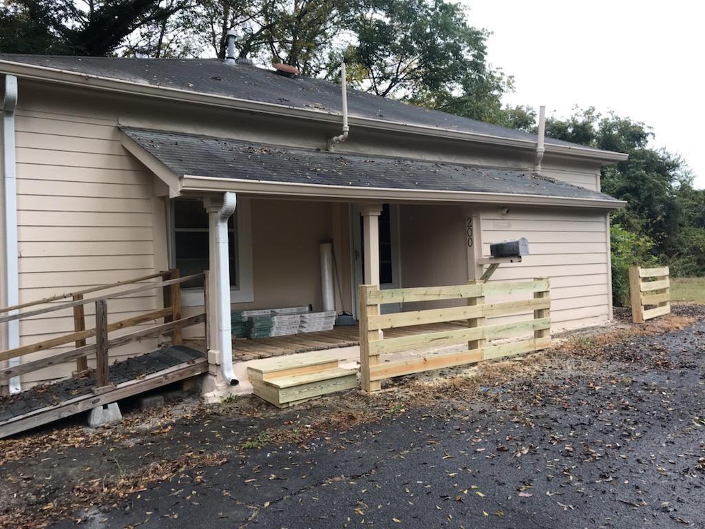 a view of a house with a large window and wooden fence