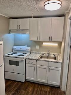 a kitchen with granite countertop a sink stove and cabinets