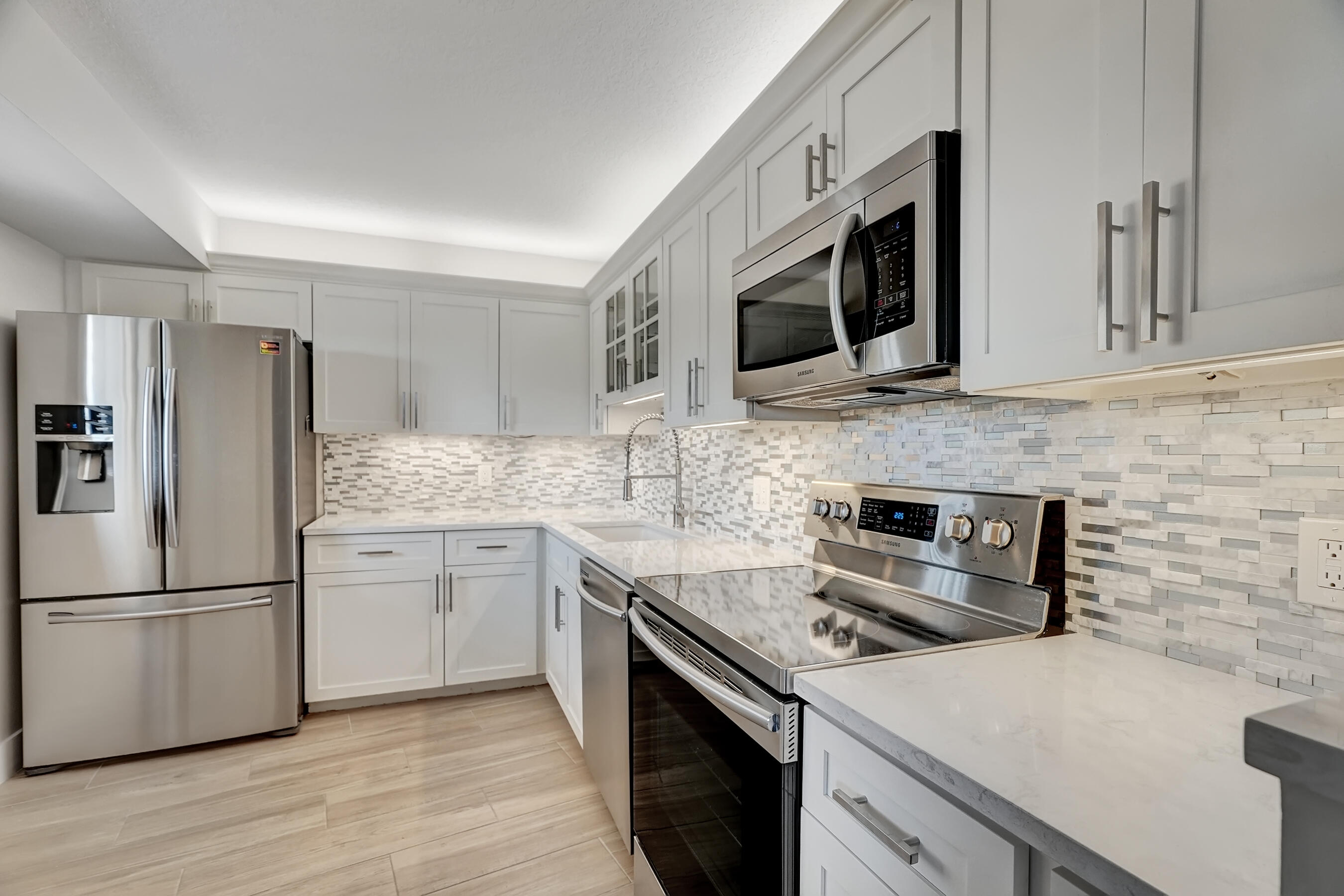 a kitchen with stainless steel appliances a stove microwave sink and refrigerator