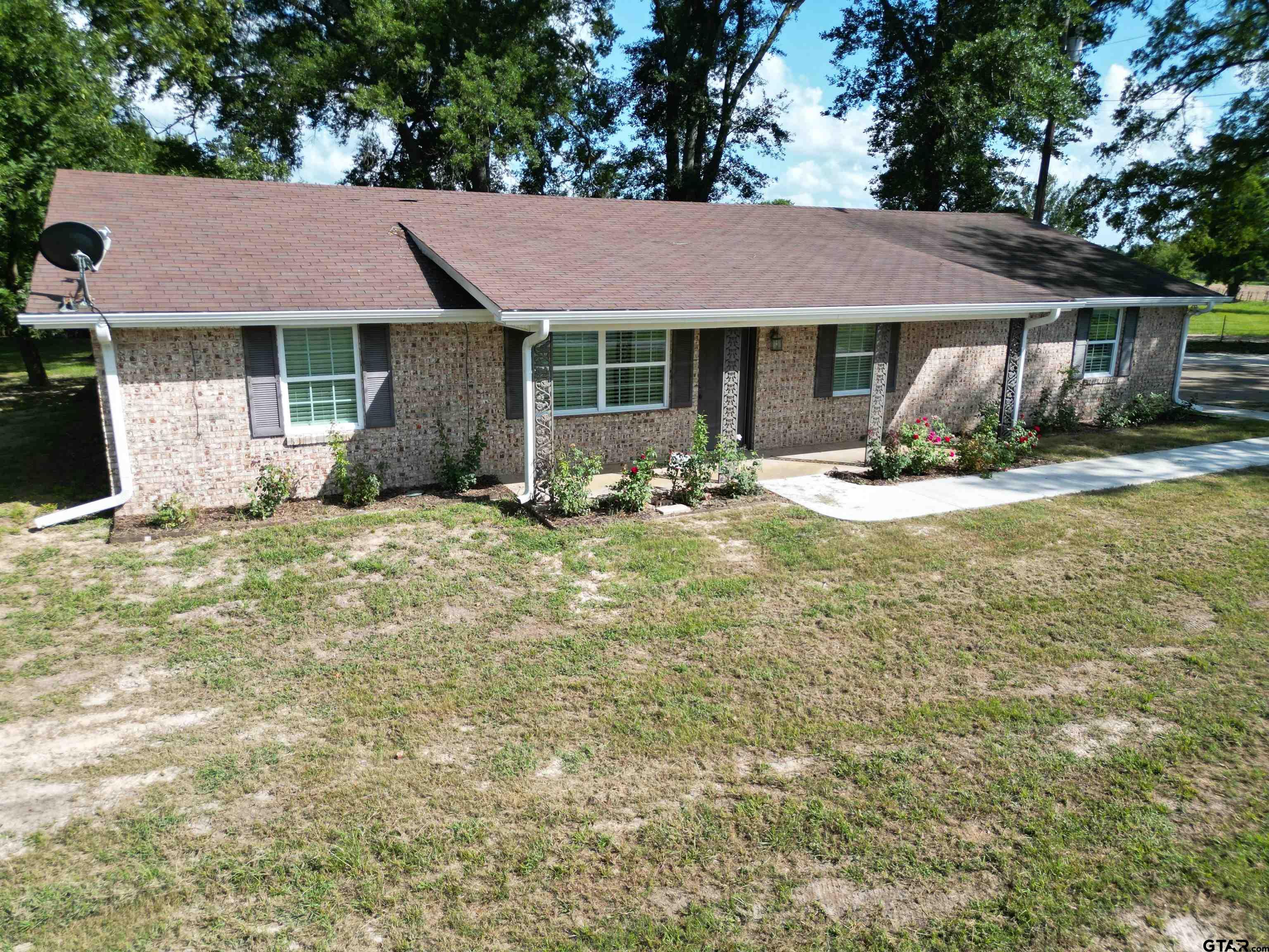 a front view of a house with a garden and yard