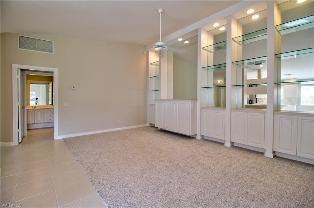 an empty room with windows and cabinet