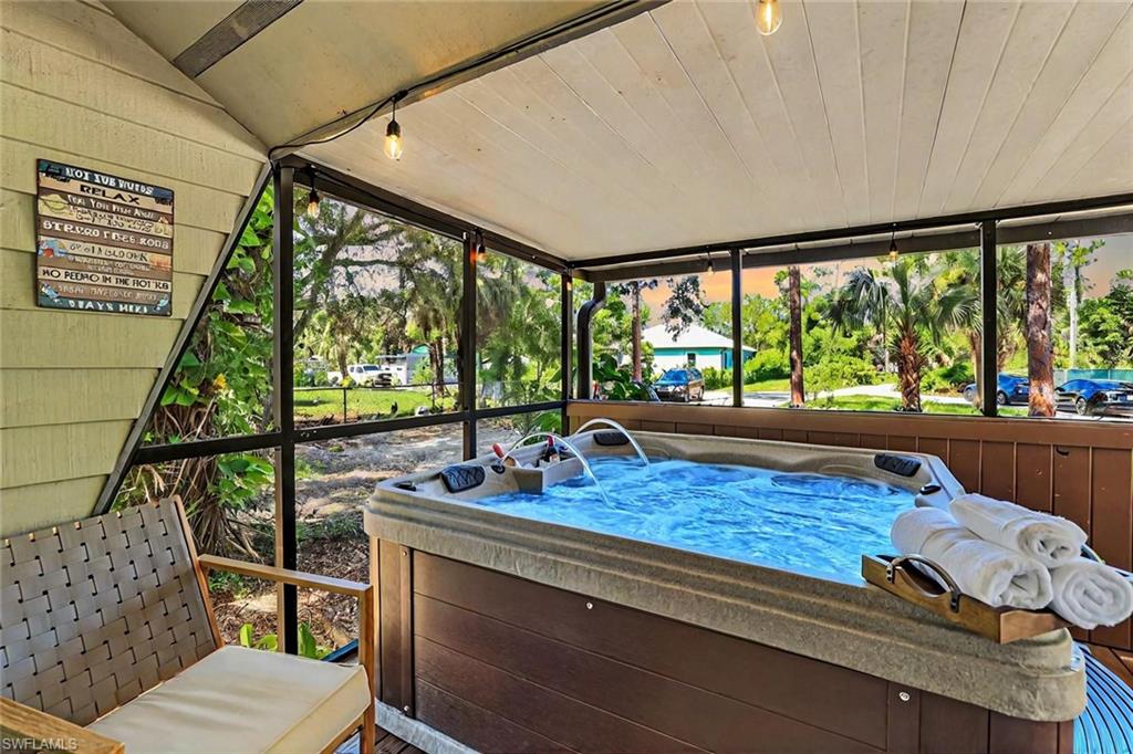 Sunroom featuring a jacuzzi, vaulted ceiling, and plenty of natural light