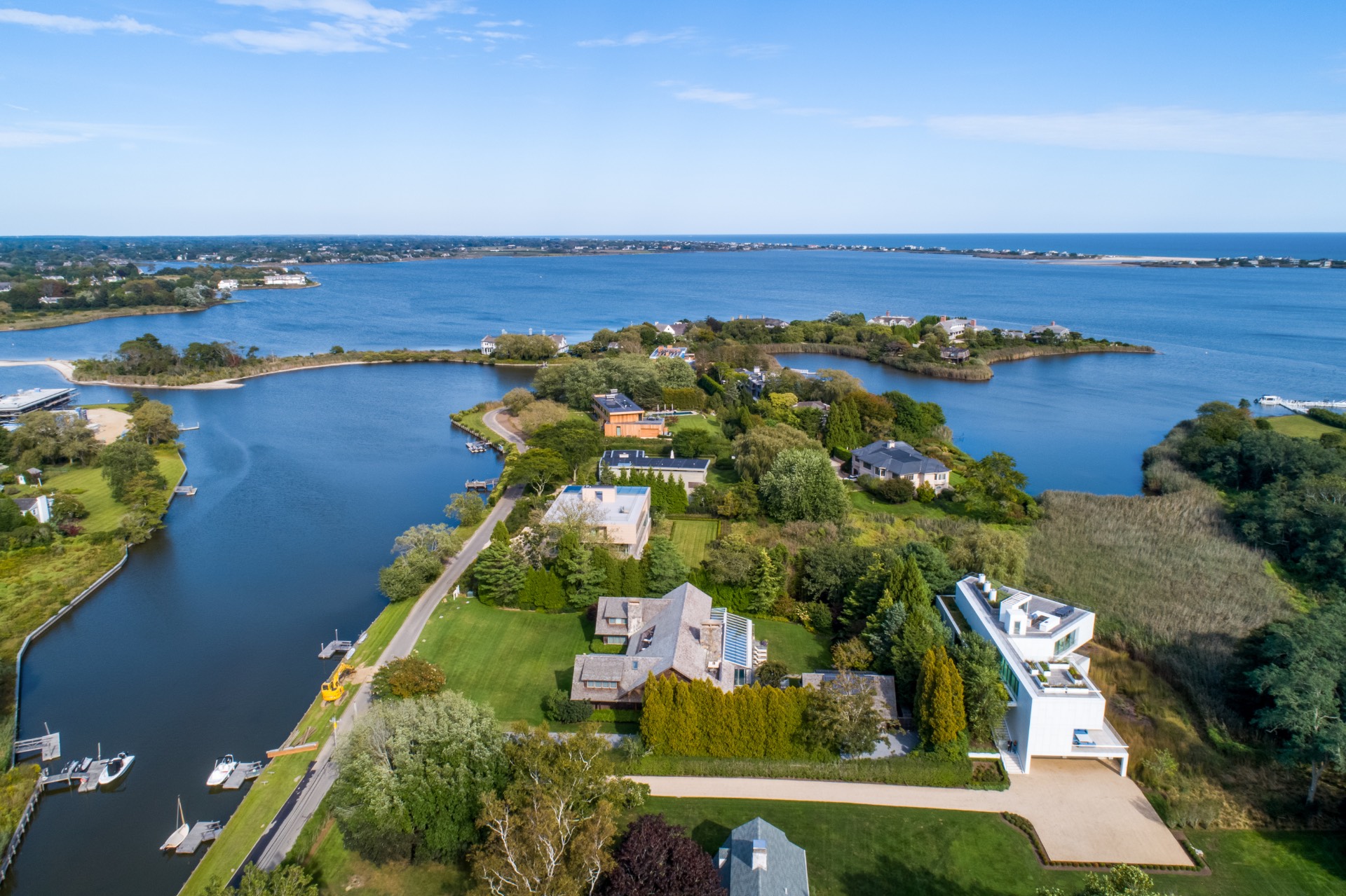 an aerial view of ocean and residential houses with outdoor space