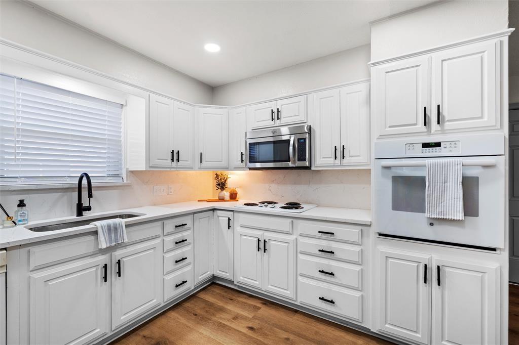 a kitchen with cabinets stainless steel appliances a sink and a window