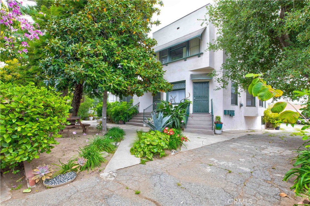 a white house with a yard and plants