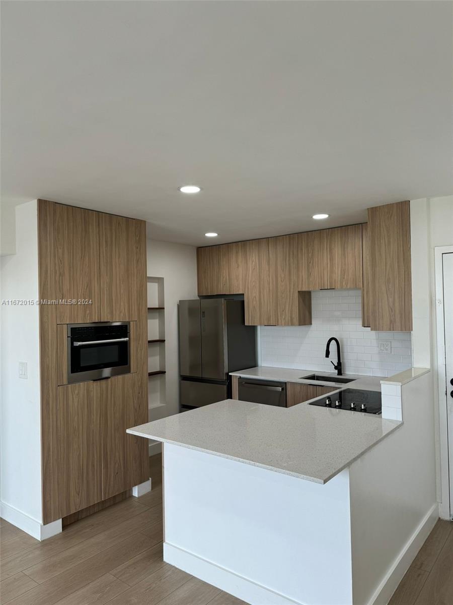 a kitchen with stainless steel appliances a refrigerator sink and microwave