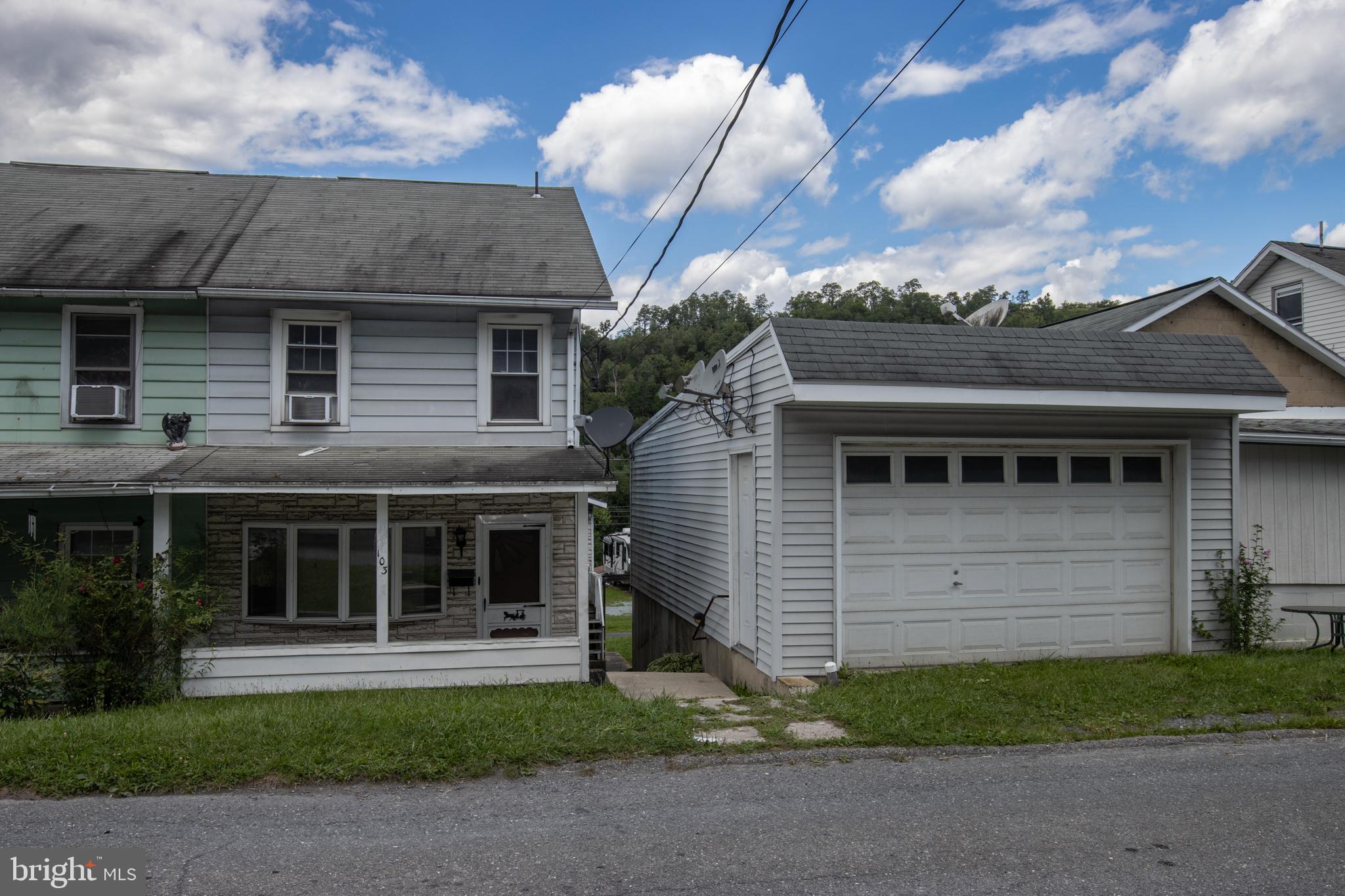 a front view of a house with a garden and garage