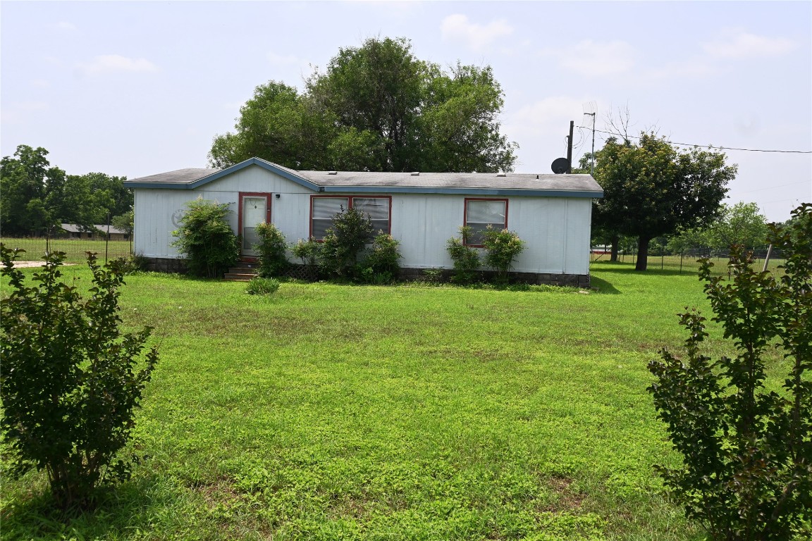 a front view of a house with yard and green space