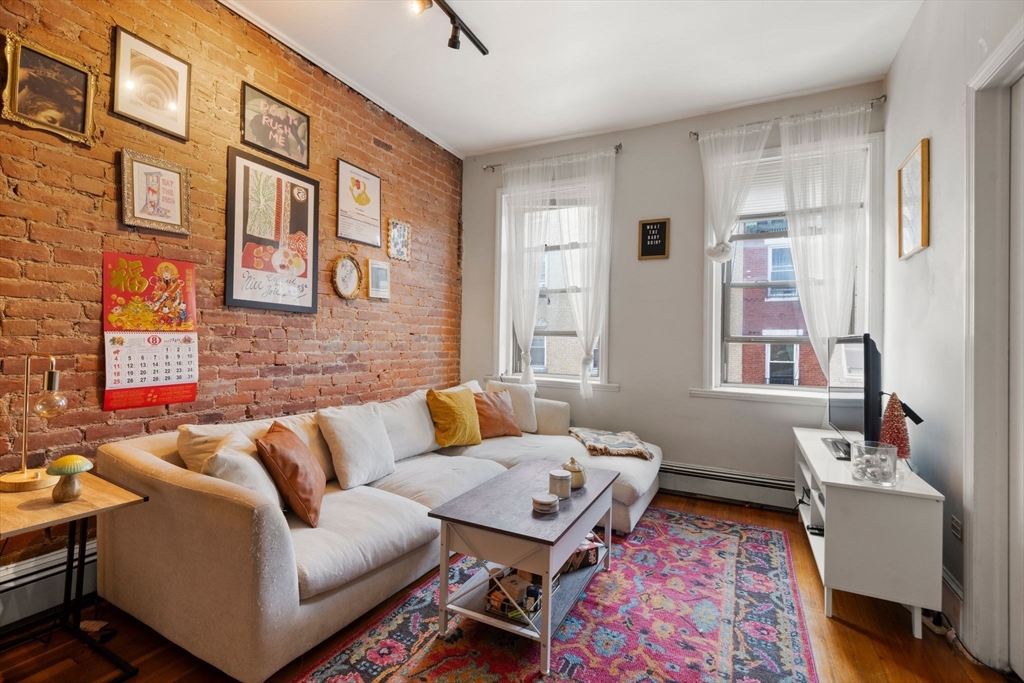 a living room with furniture wooden floor and a window