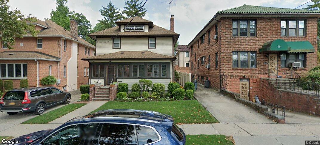 View of front of home with cooling unit and a front yard