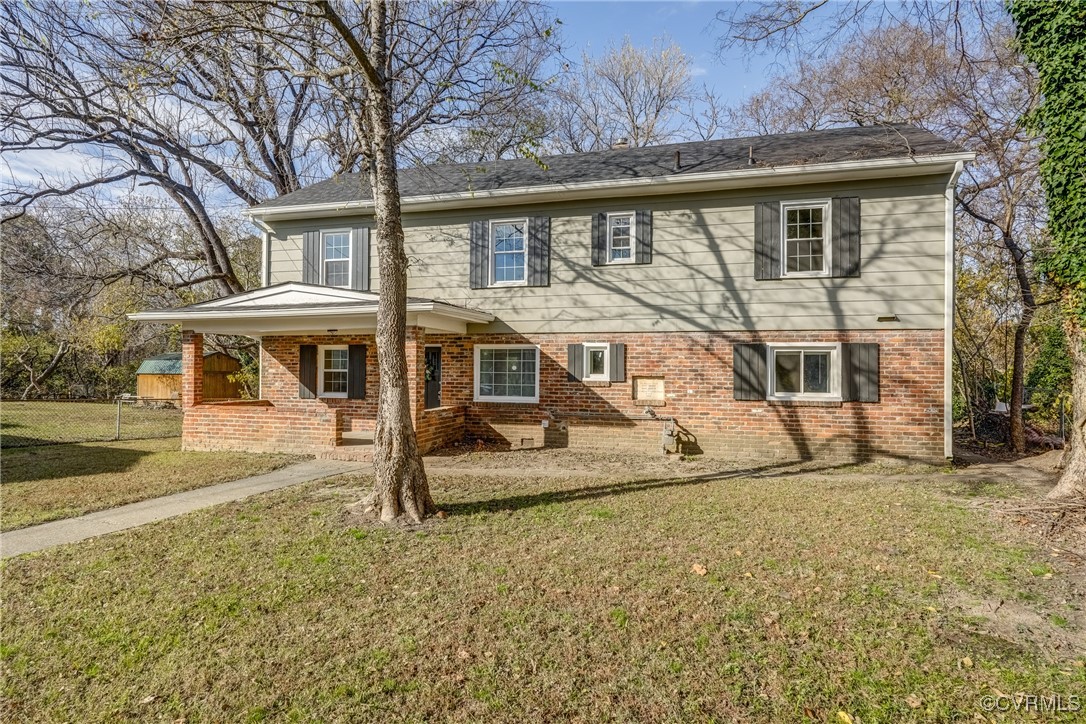 Back of property featuring a yard and a porch