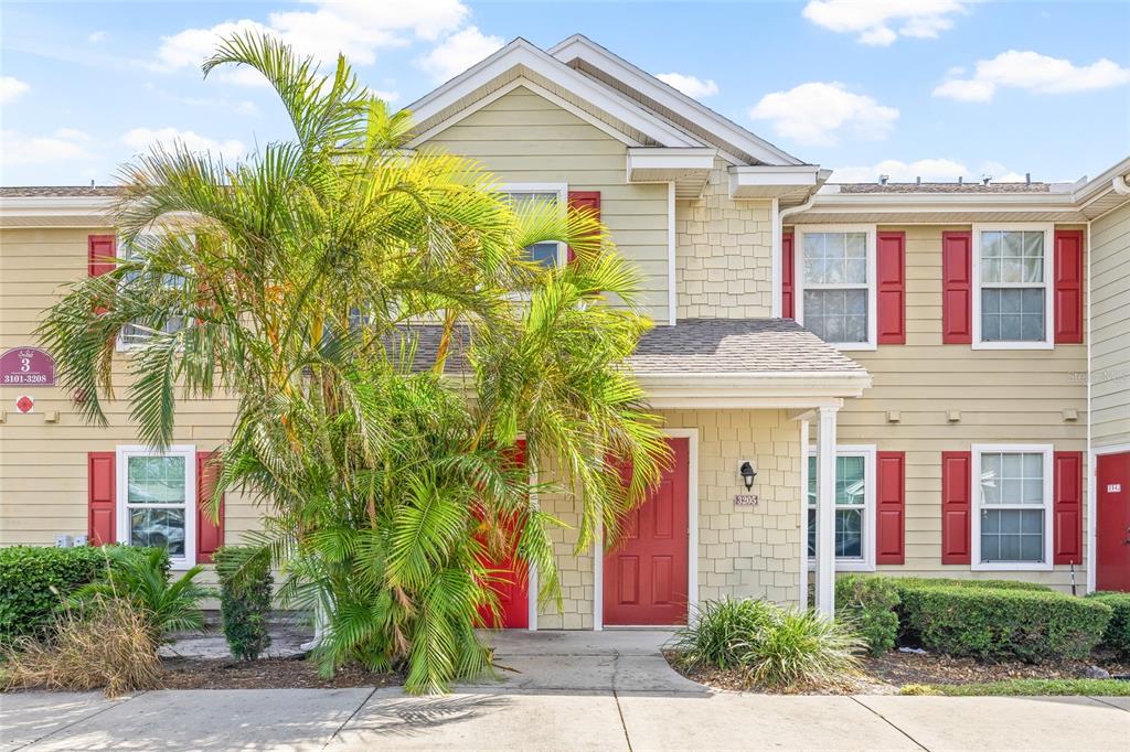 a front view of a house with a yard and potted plants