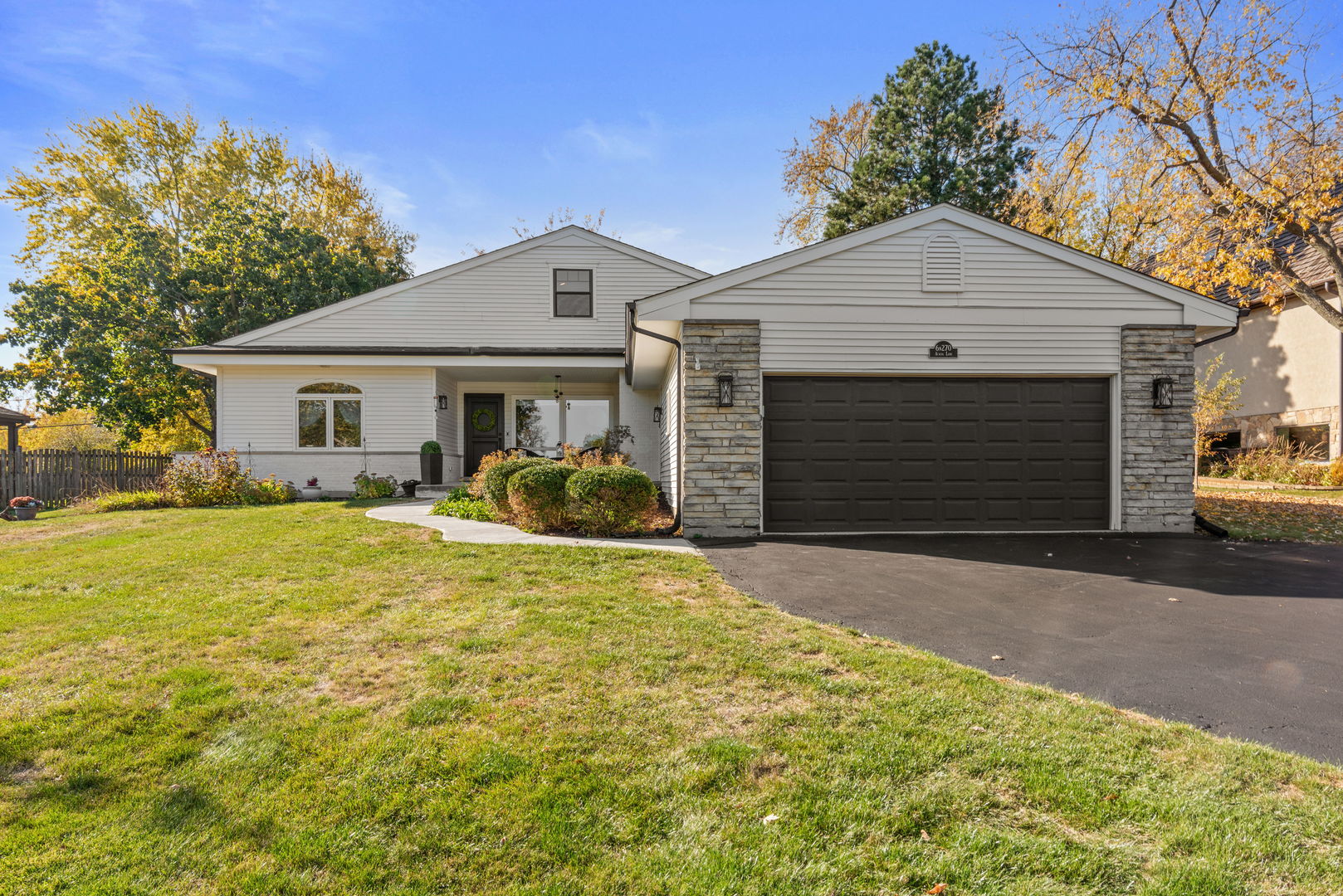 a front view of a house with yard and parking