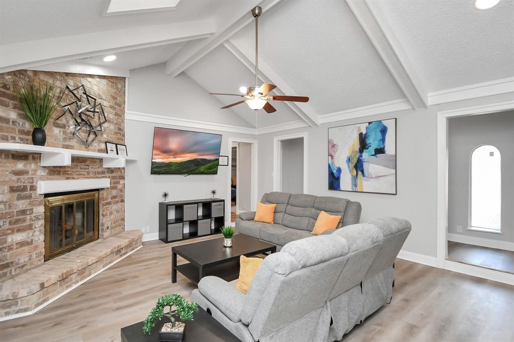 a living room with furniture a flat screen tv and a fireplace