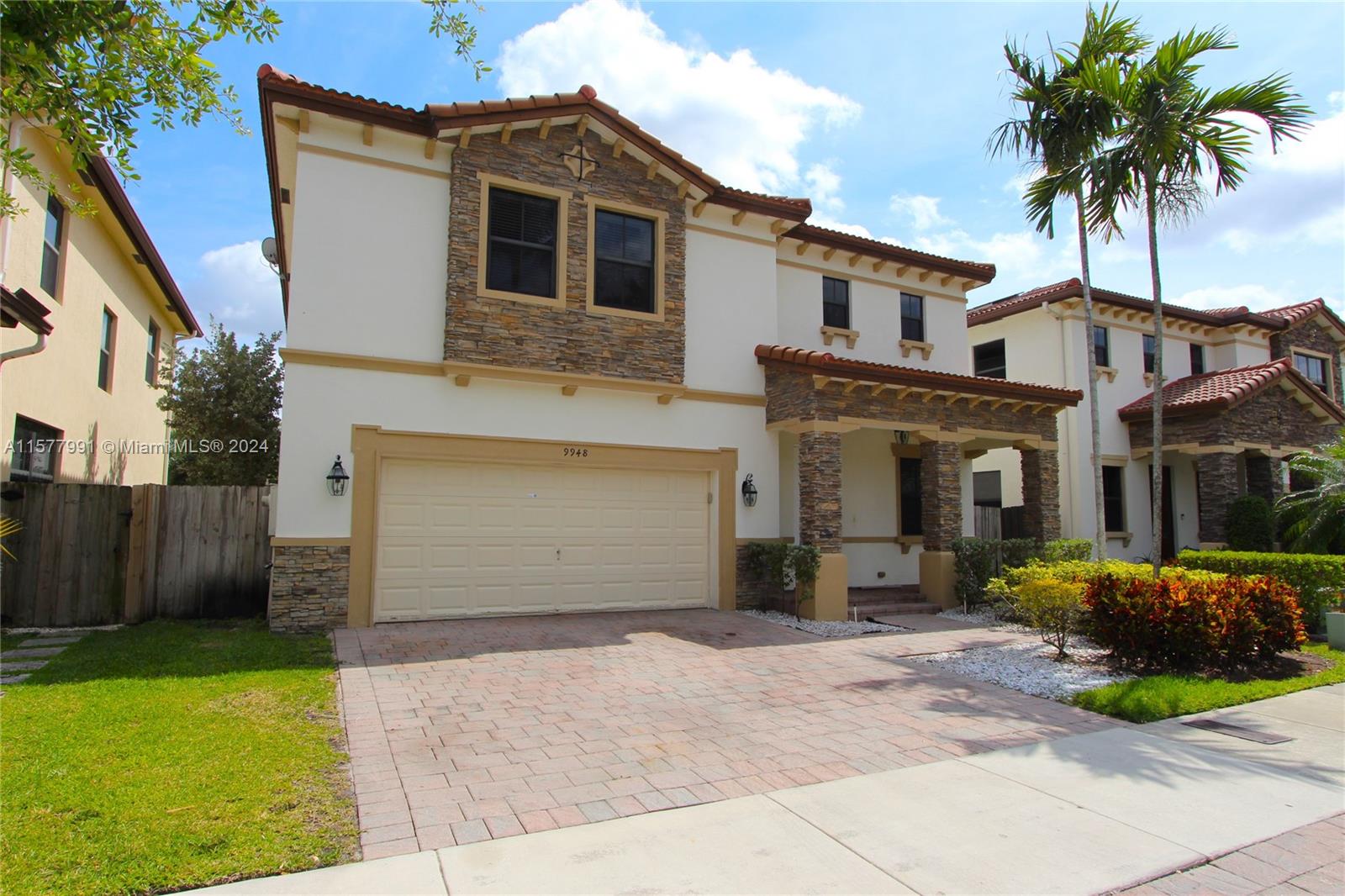 a front view of a house with a garden and garage