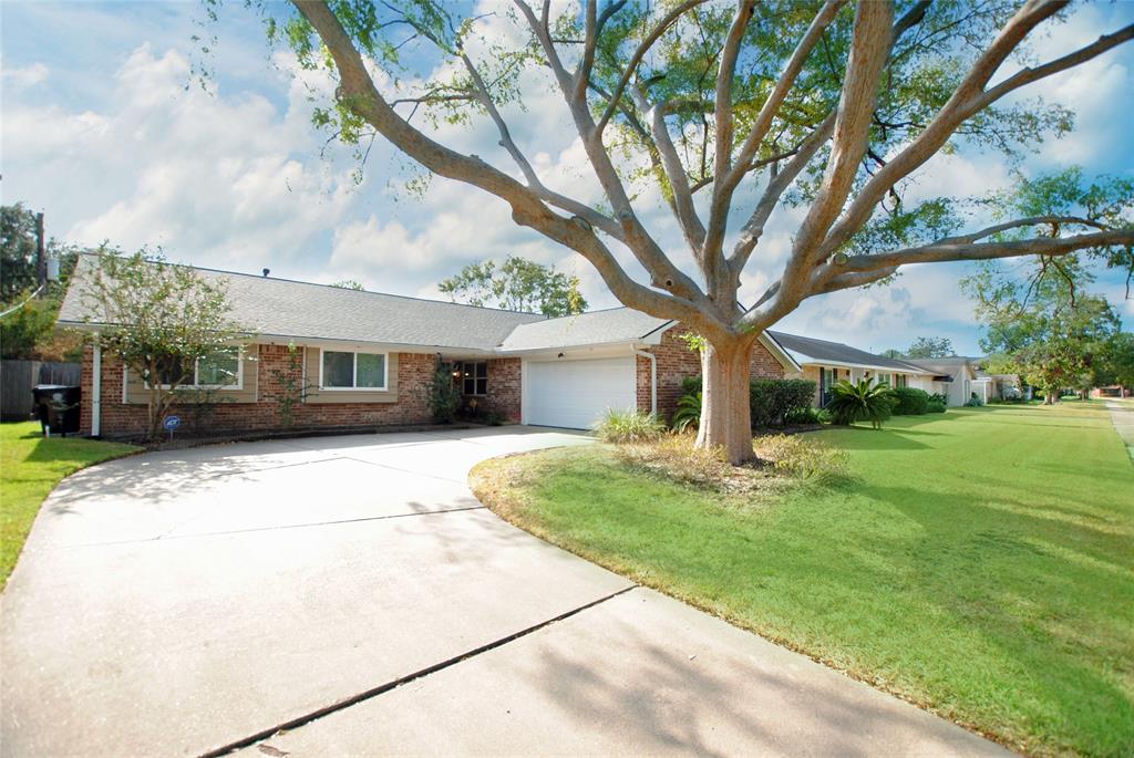 a front view of a house with yard and green space