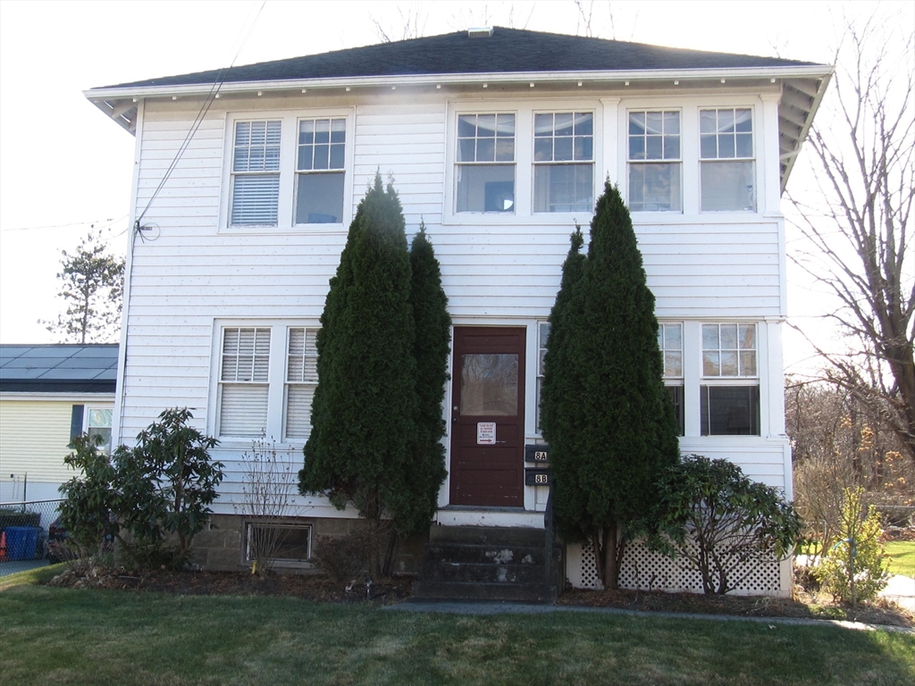 a front view of a house with a garden and plants