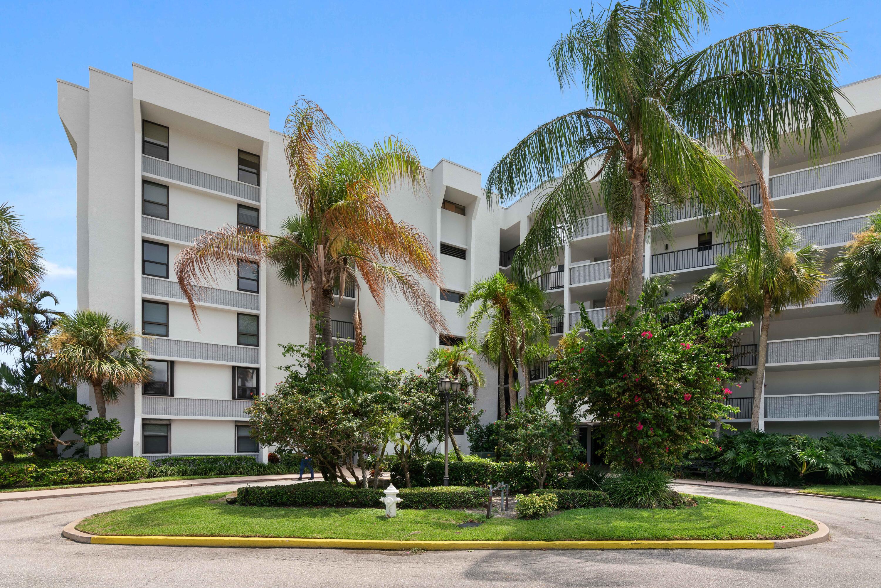 a front view of multi story residential apartment building with yard and green space