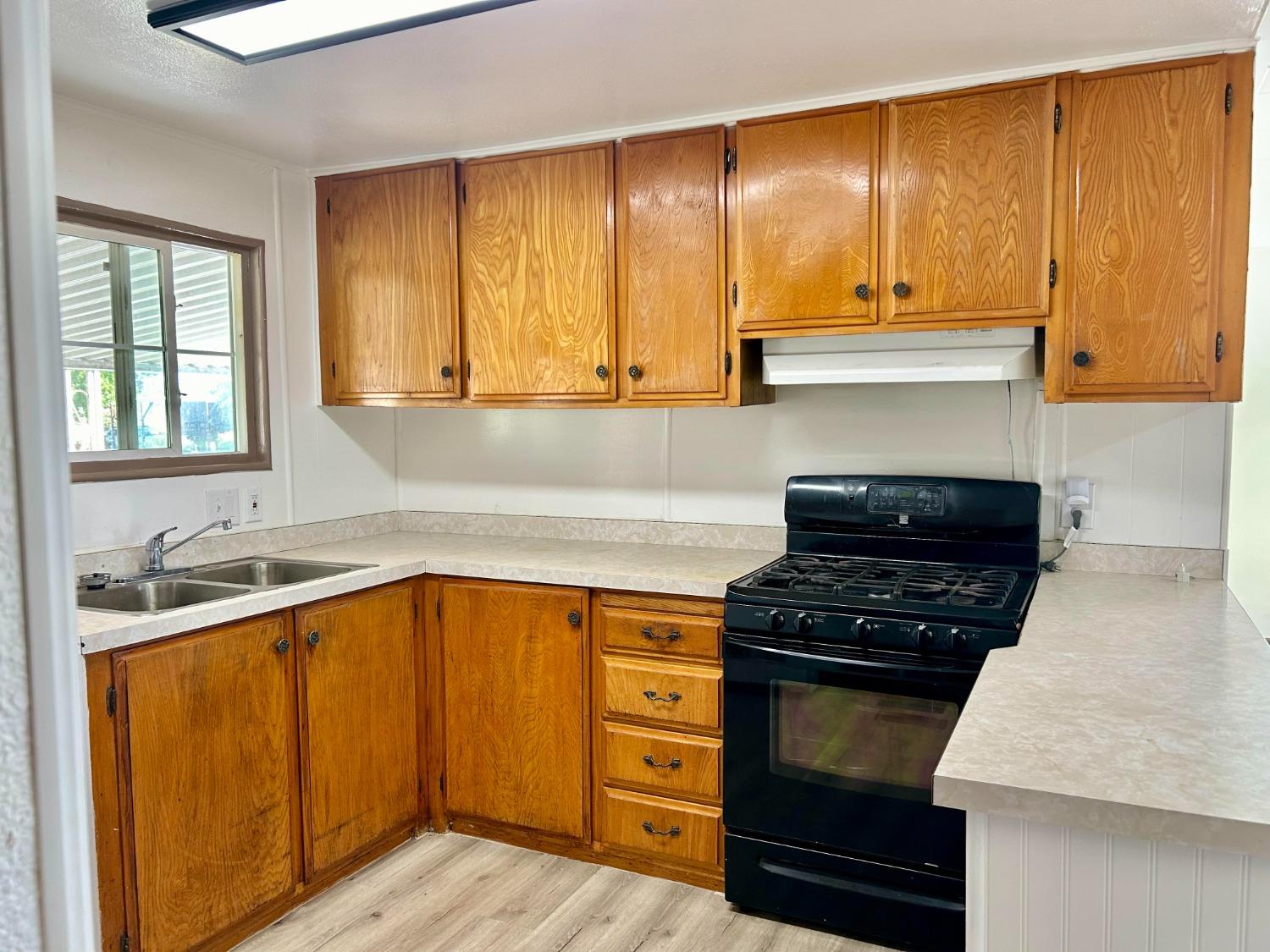 a kitchen with a sink a stove and cabinets