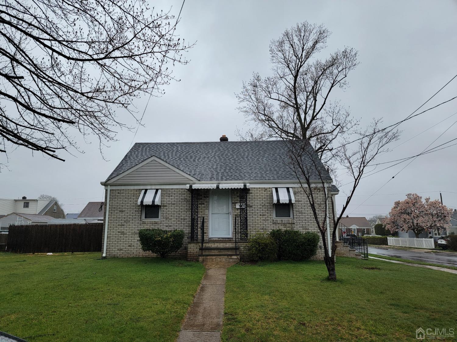 a front view of a house with a garden and trees