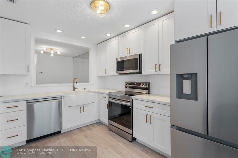 a kitchen with white cabinets stainless steel appliances and a sink