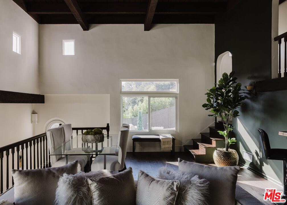 a living room with furniture stairs and a potted plant