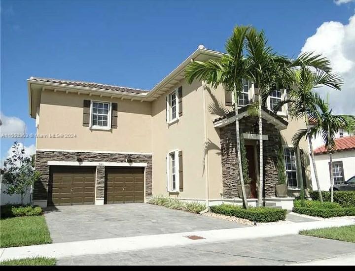 a front view of a house with a yard and garage