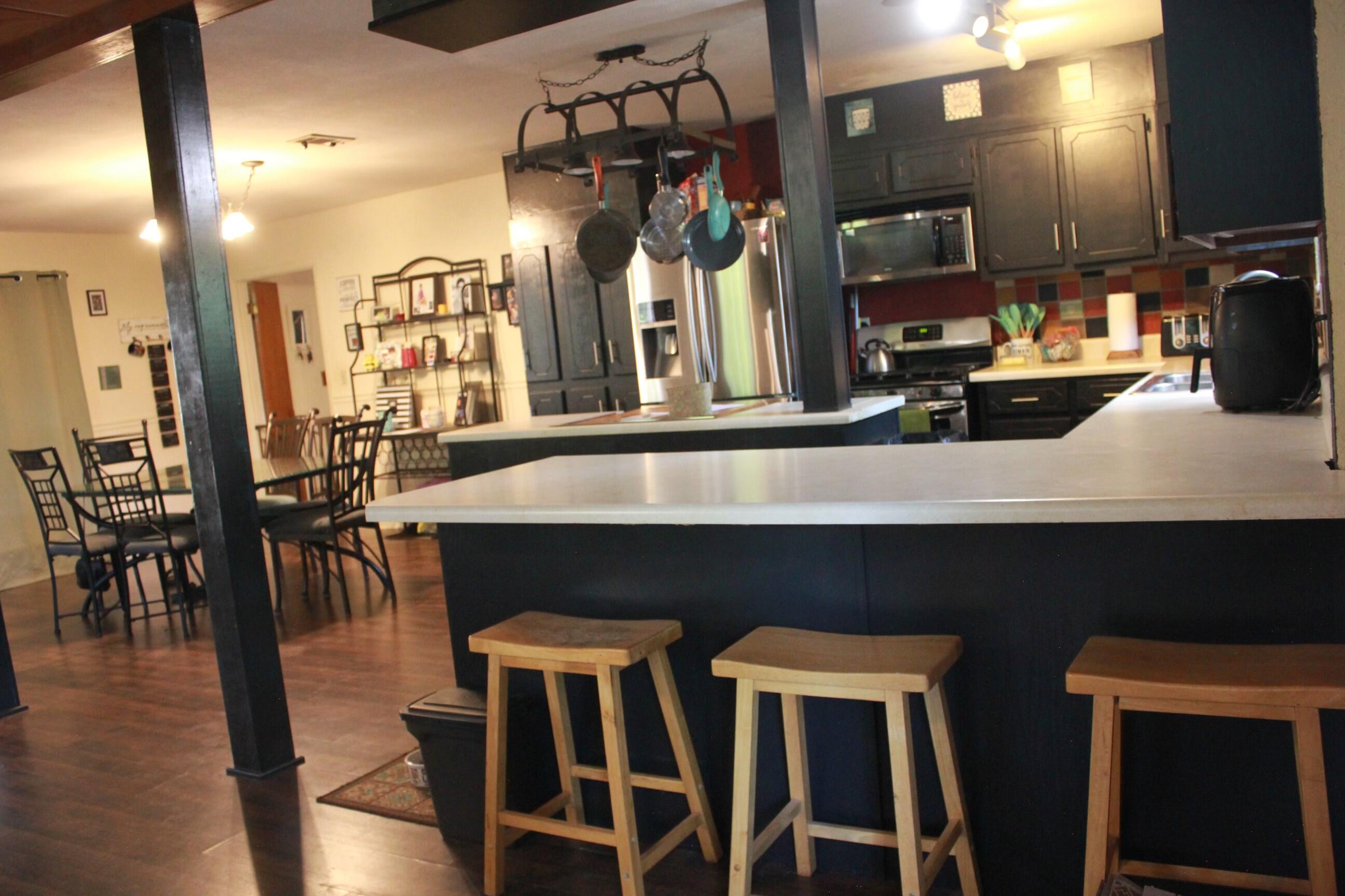 a kitchen with chairs and wooden floor