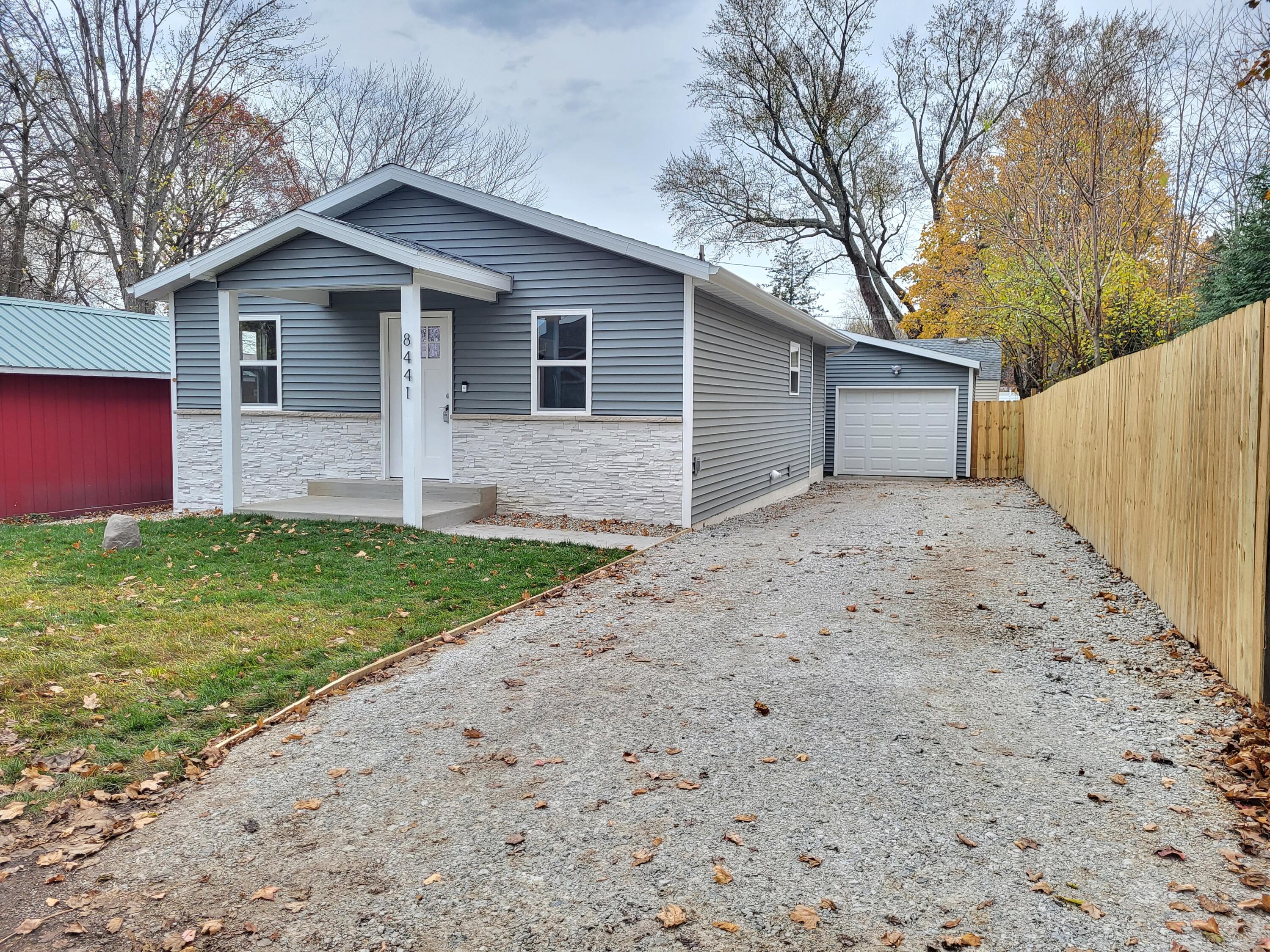 a front view of house with yard and trees in the background