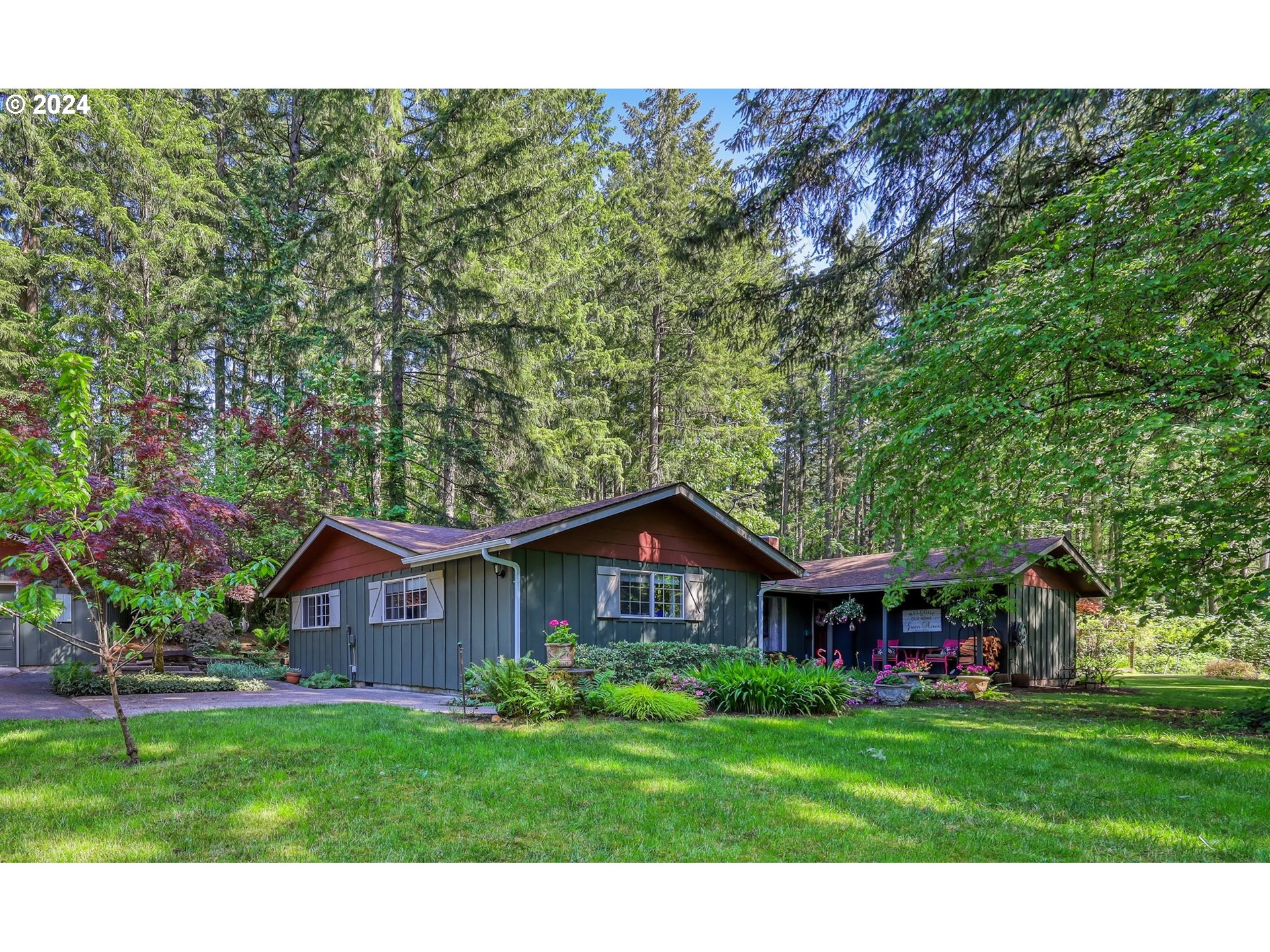 a view of a big house with a big yard and large trees