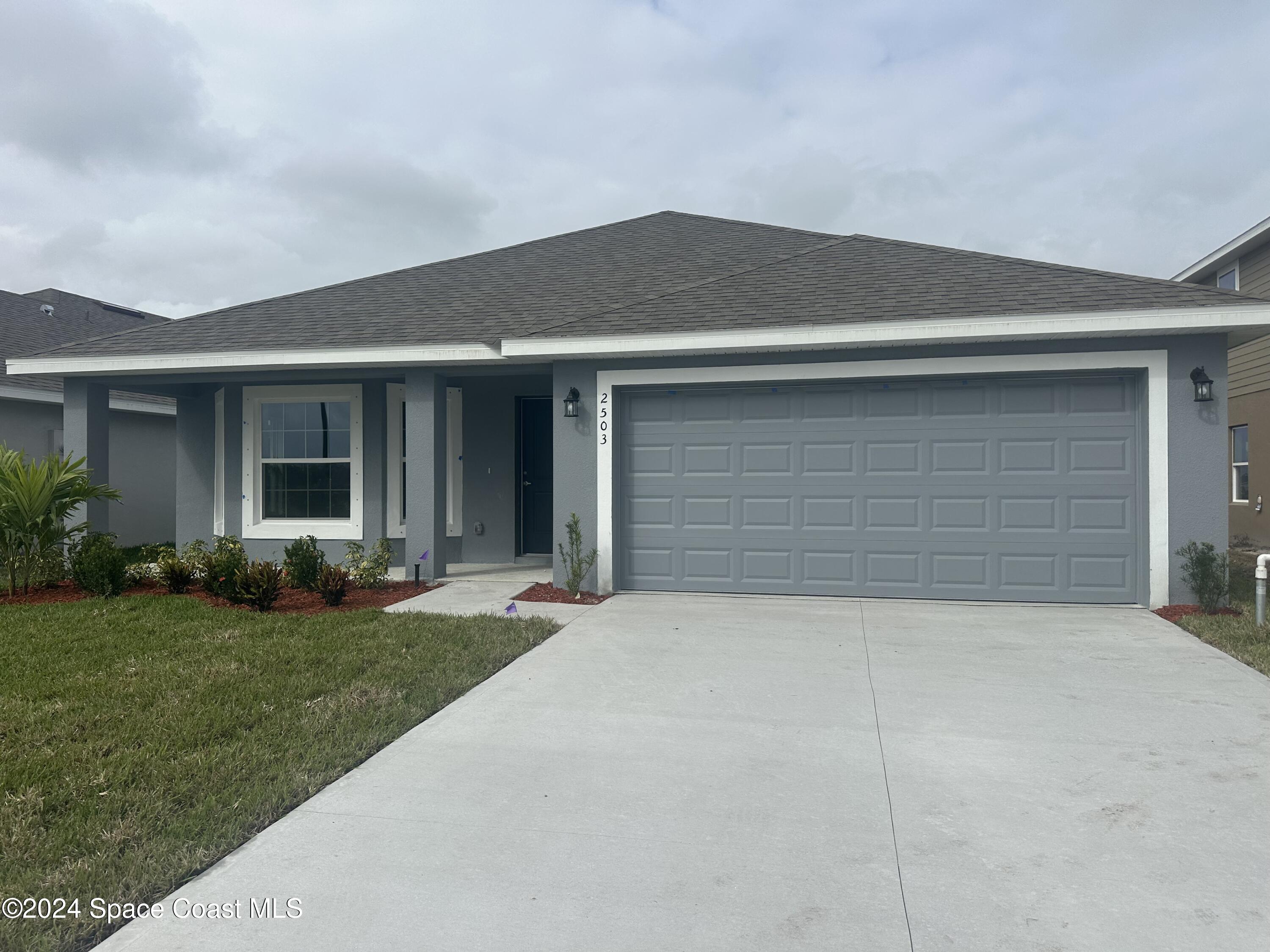 a front view of a house with a yard and garage