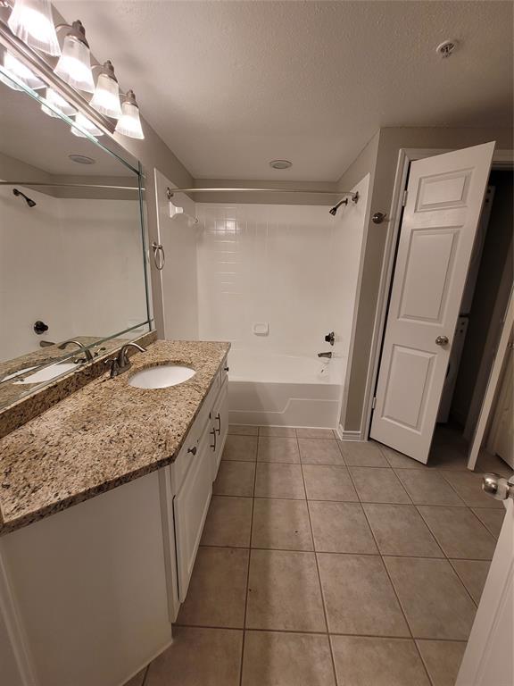 a bathroom with a granite countertop sink a mirror and a vanity