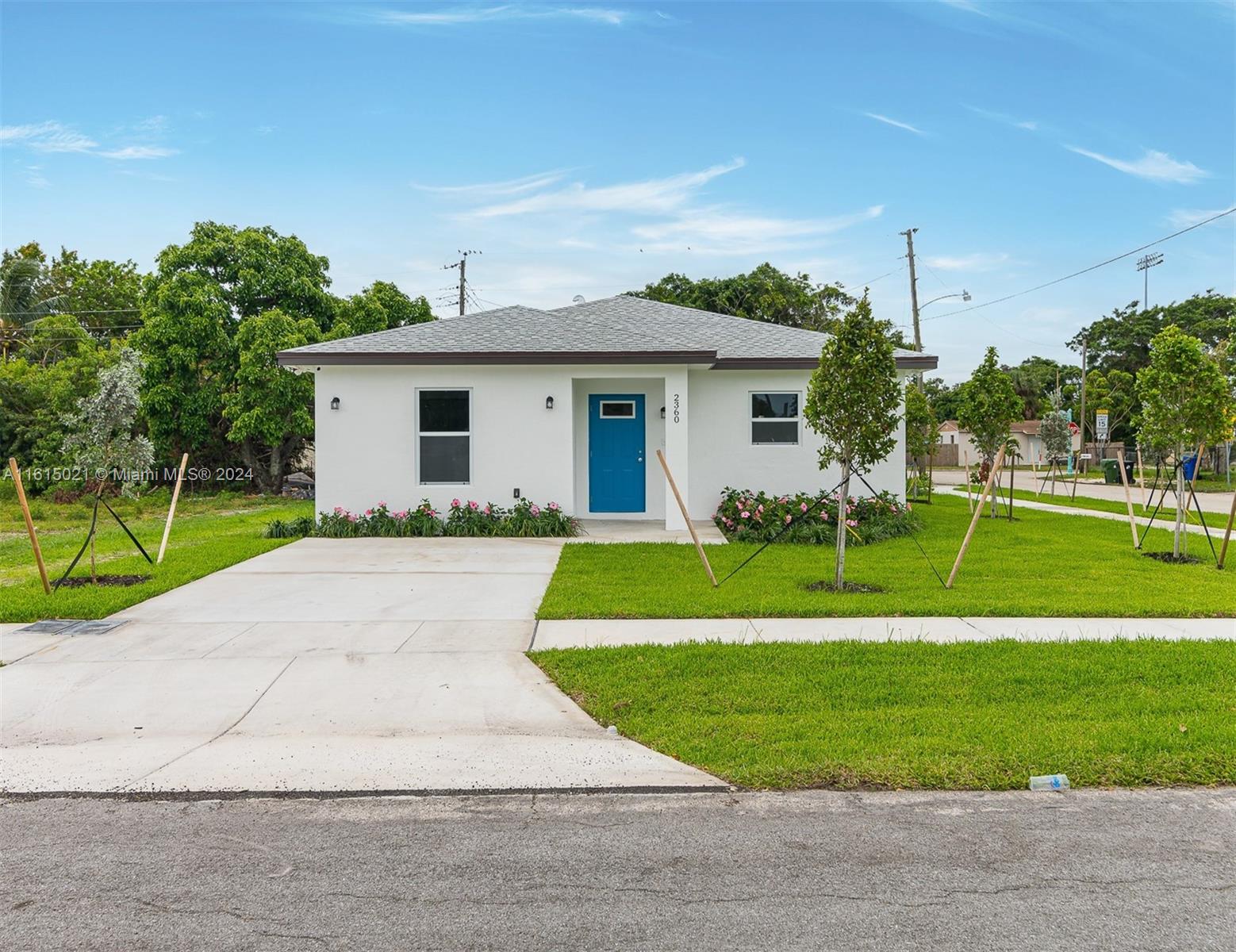 a view of a house with a big yard and palm trees