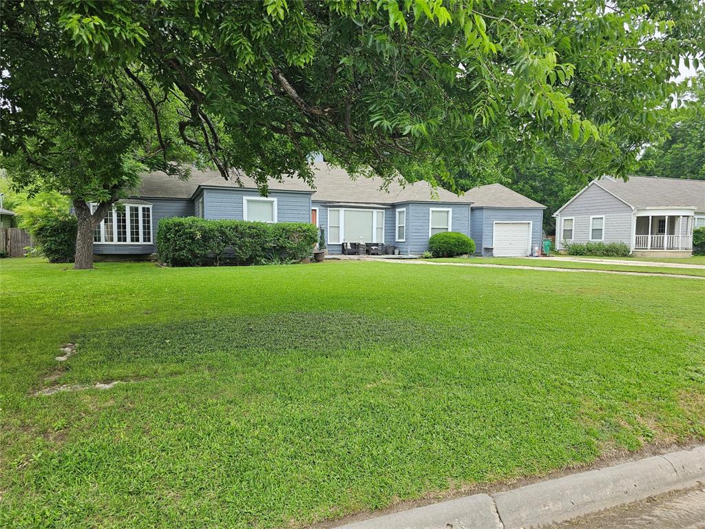 a front view of a house with a yard and trees